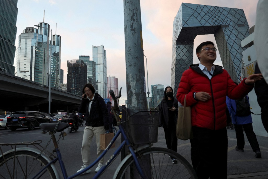 Commuters walk beside skyscrapers at the central business district (CBD) in Beijing, China March 27, 2025. REUTERS/Florence Lo     TPX IMAGES OF THE DAY