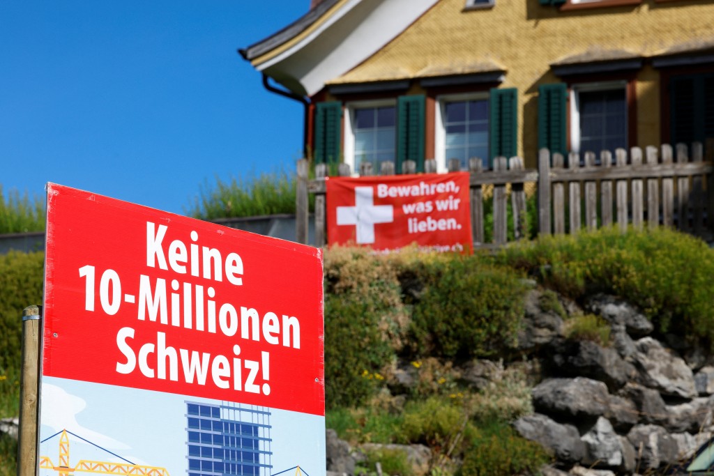 Signs stand in front of a building, on the day of the vote on a plan backed by the right-wing Swiss People's Party (SVP) to limit population growth to 10 million inhabitants, in Appenzell, Switzerland, June 14, 2026. (Reuters)