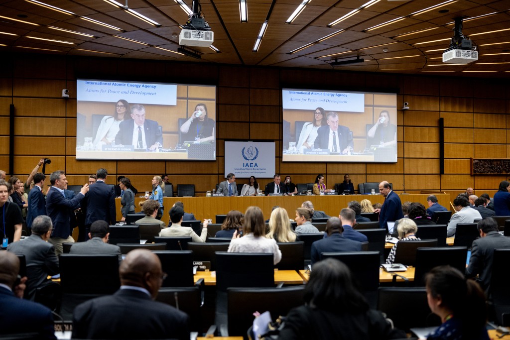 The Chairperson of the IAEA’s Board of Governors for 2025–2026 David Grainge Biggs, who is also Australia’s Resident Representative to the IAEA and Permanent Representative to the United Nations, is seen on two screens (C) as he opens the International Atomic Energy Agency (IAEA) Board of Governors' Meeting at the agency's headquarters in Vienna, Austria on June 8, 2026. (Photo by Joe Klamar / AFP)