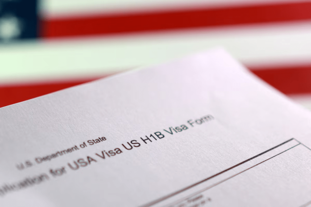 A U.S. flag and a U.S. H-1B Visa application form are seen in this illustration taken, September 22, 2025. REUTERS/Dado Ruvic/Illustration/ File Photo