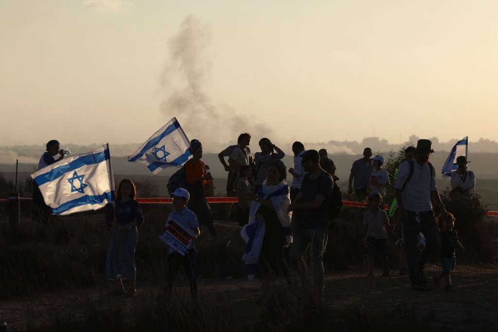 Israeli right-wing protesters gather on a hill overlooking the besieged Gaza Strip near the border fence on July 30, 2025, during a rally to mark 20 years since Israel's withdrawal from Gaza. (Photo by Menahem KAHANA / AFP)