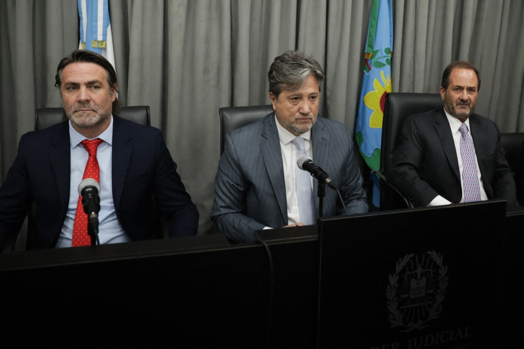 Photo by STRINGER / AFP Judges Alberto Ortolani (L), Alberto Gaig (C) and Pablo Rolon attend a court hearing in the trial over the death of Argentine football legend Diego Maradona in San Isidro, Buenos Aires province, Argentina, on October 8, 2026.