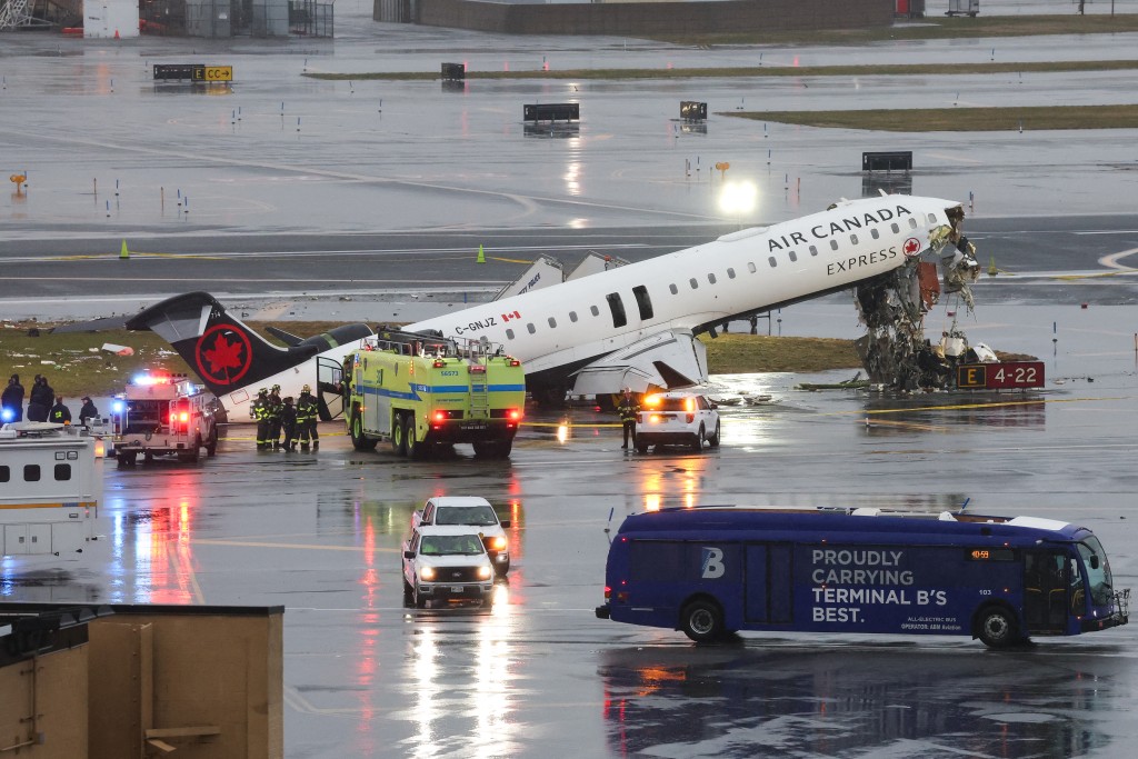 Photo by TIMOTHY A. CLARY / AFP  An Air Canada Express CRJ-900 sits on the runway after colliding with a Port Authority fire truck at LaGuardia Airport in New York, on March 23, 2026.