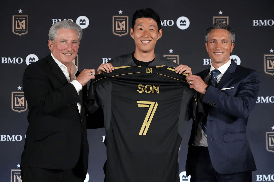 Aug 6, 2025; Los Angeles, California, USA; Son Heung-min (center) poses with LAFC lead managing owner Bennett Rosenthal (left) and general manager John Thorrington during an LAFC introductory press conference at BMO Stadium. Mandatory Credit: Kirby Lee-Imagn Images
