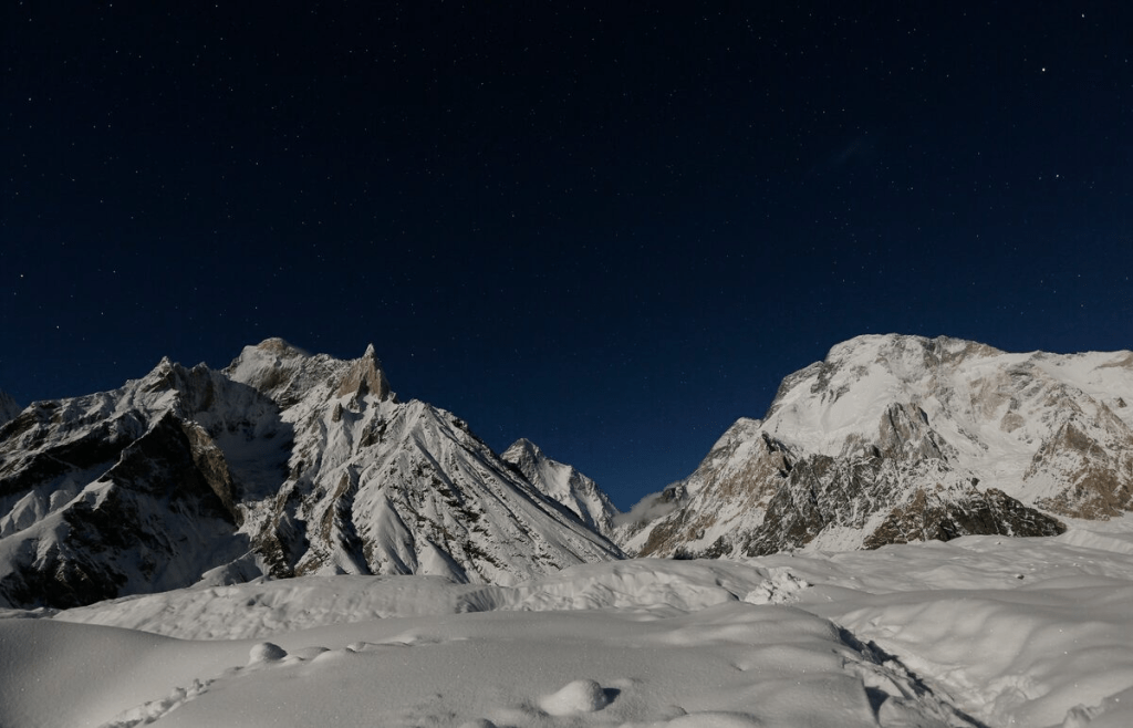 The world's second largest mountain, the 8,611 meter high K2 (seen in the distance), and the 8,051 meter high Broad Peak (R), are illuminated by the moon at Concordia, the confluence of the Baltoro and Godwin-Austen glaciers, in the Karakoram mountain range in Pakistan September 7, 2014. REUTERS/Wolfgang Rattay/File Photo