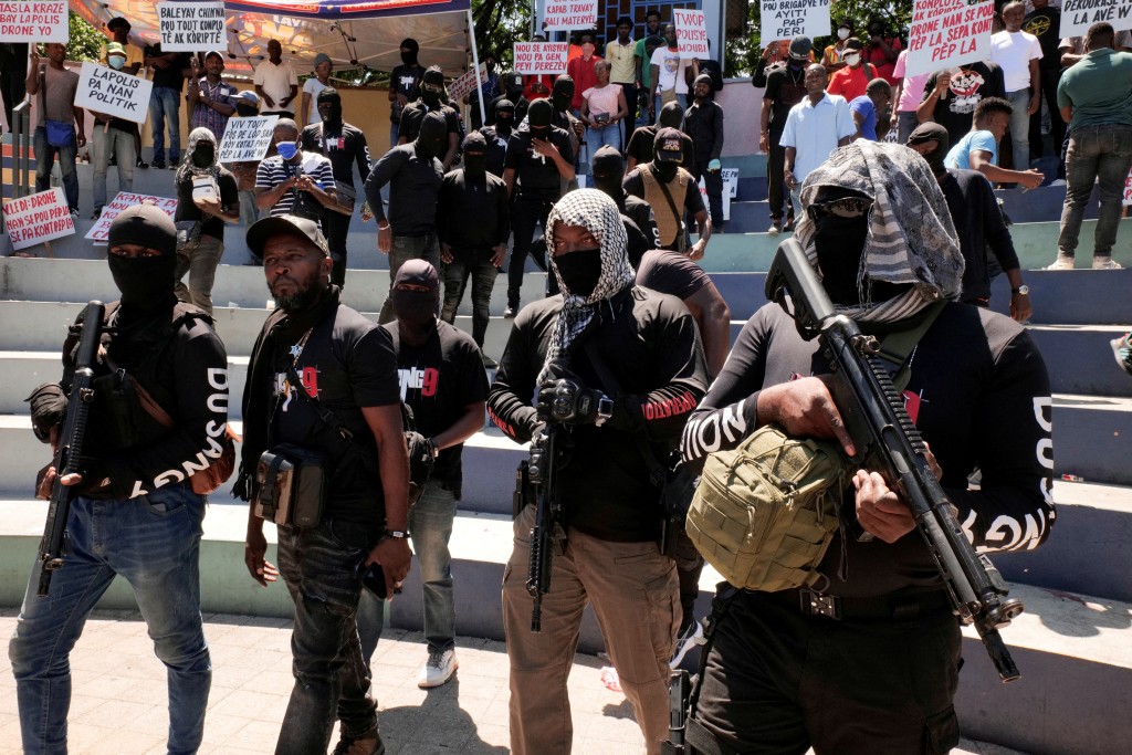 Former police officer "Commander Samuel" walks on the street surrounded by armed men from his group called Du Sang 9 during a protest against insecurity, Port-au-Prince, Haiti June 28, 2025. (Reuters)