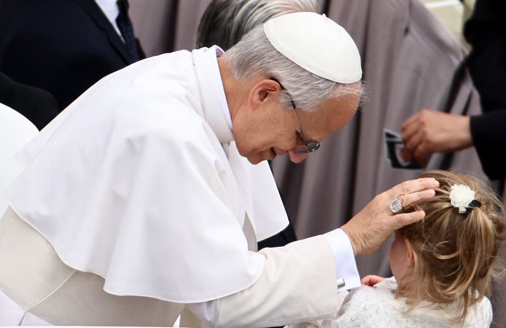  Pope Leo XIV blesses a child on the day of his first general audience in St. Peter's Square at the Vatican, May 21, 2025. REUTERS/Yara Nardi