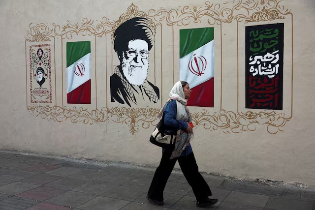 A woman walks by a mural depicting Iran's late Supreme Leader Ayatollah Ali Khamenei, on a street in Tehran, Iran, August 13, 2026. Majid Asgaripour/WANA (West Asia News Agency) via REUTERS/File Photo