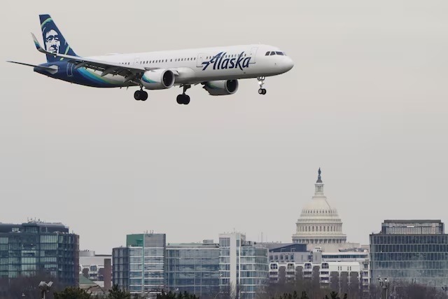 An Alaska Airlines aircraft flies past the U.S. Capitol before landing at Reagan National Airport in Arlington, Virginia, U.S., January 24, 2022. REUTERS/Joshua Roberts 