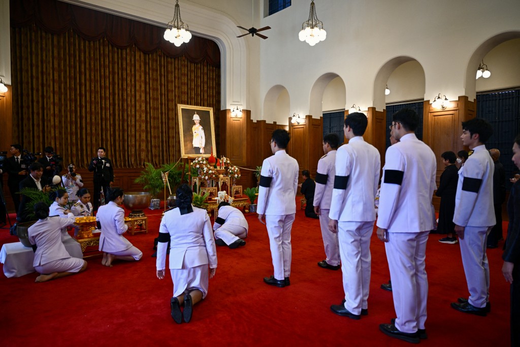 Photo by ANTHONY WALLACE / AFP. Officials pay respects in front of a portrait of the late Thai Princess Bajrakitiyabha Mahidol in the royal throne hall at the Grand Palace in Bangkok on June 13, 2026.