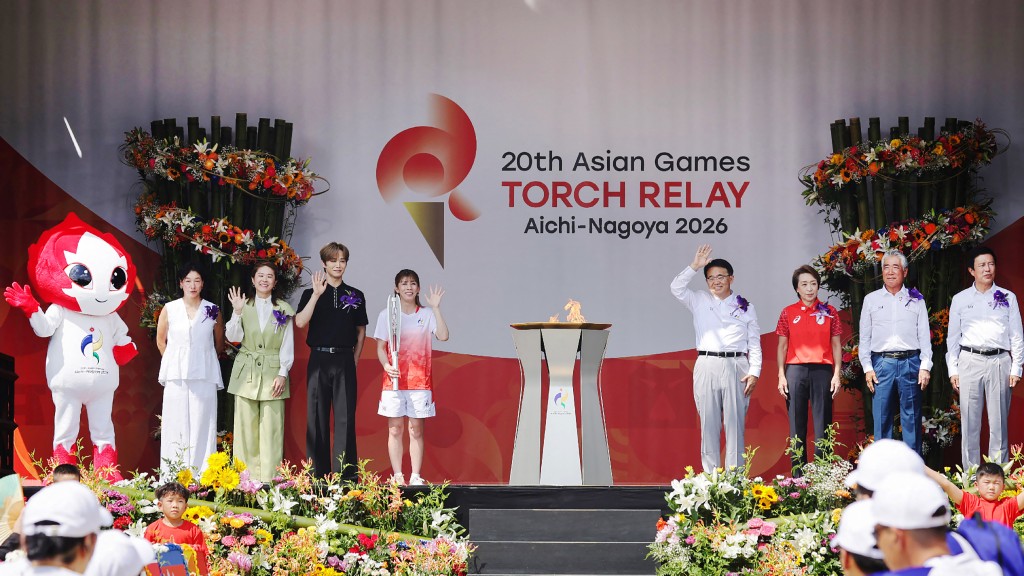 Japanese three-time Olympic wrestling gold medallist Saori Yoshida (C) serves as the first torchbearer in the Aichi–Nagoya Asian Games torch relay in Nagoya city on August 22, 2026 (Photo by JIJI PRESS / JIJI PRESS / AFP) / JAPAN OUT