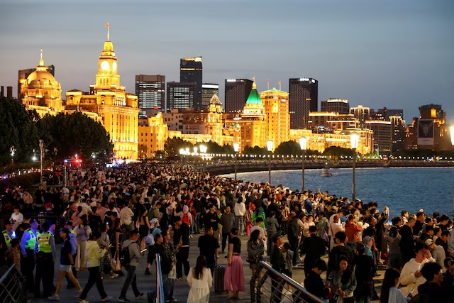 FILE PHOTO: People enjoy the city lights at the Bund during the five-day Labour Day holiday in Shanghai, China May 4, 2025. REUTERS/Go Nakamura/File Photo/File Photo 