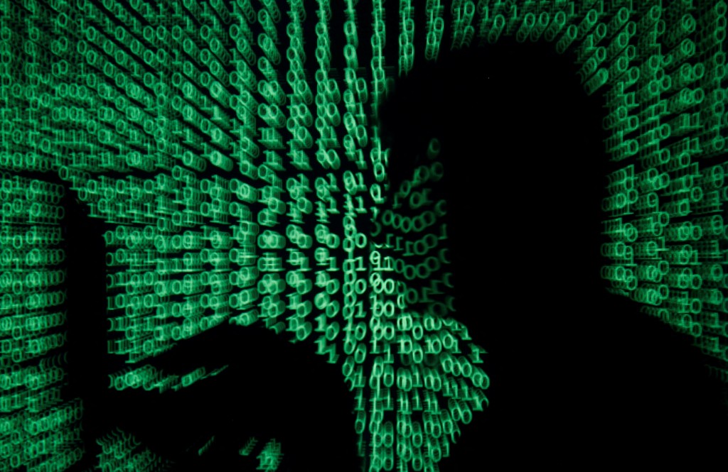 A man holds a laptop computer as cyber code is projected on him in this illustration picture taken on May 13, 2017. REUTERS/Kacper Pempel/Illustration