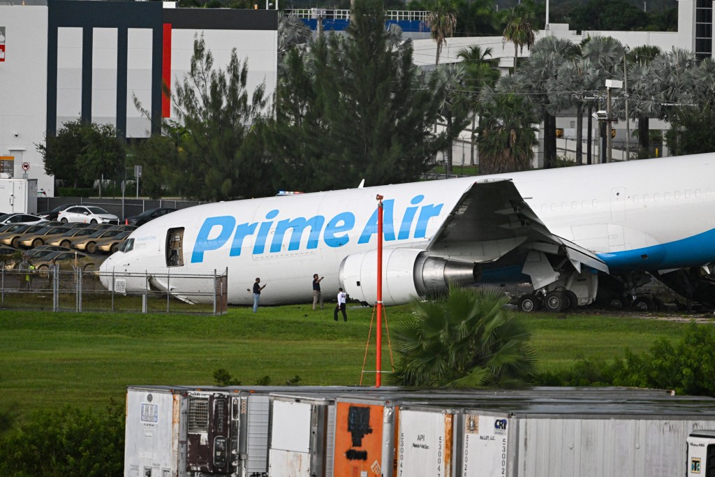 Officials investigate a Prime Air cargo plane at Miami International Airport after it overran the runway at Miami International Airport in Miami, Florida, on September 6, 2026. (AFP)