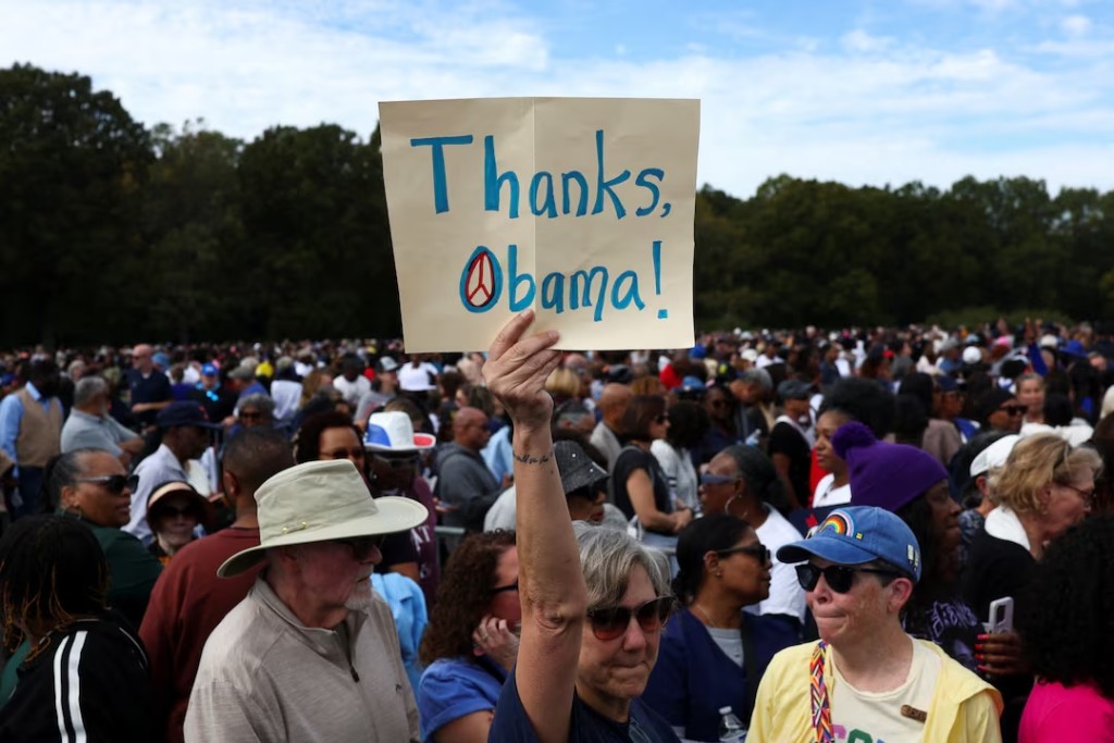 A supporter holds a sign as people arrive at a rally by former US President Barack Obama, Democratic Senator Jon Ossoff, and Democratic gubernatorial nominee Keisha Lance Bottoms, ahead of the midterm elections in Morrow, Georgia, US, October 28, 2026. REUTERS/Edgar Su