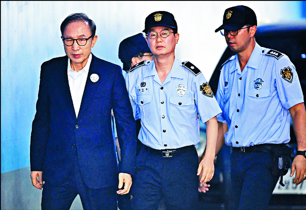 As well as serving a jail term, Lee Myung Bak, arriving in court for his trial in 2018, must pay a massive fine and forfeit assets. AFP As well as serving a jail term, Lee Myung Bak, arriving in court for his trial in 2018, must pay a massive fine and forfeit assets. AFP