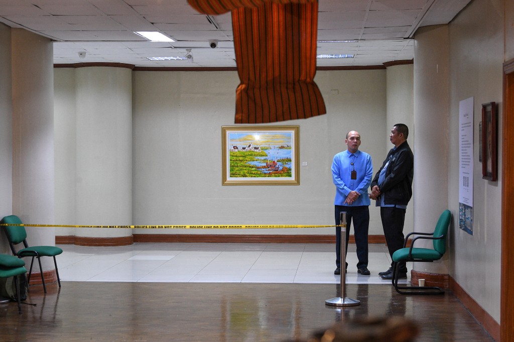 Photo by TED ALJIBE / AFP  Senate security personnel stand guard near the site where gun shots were fired night before inside the Senate building in Manila on May 14, 2026.