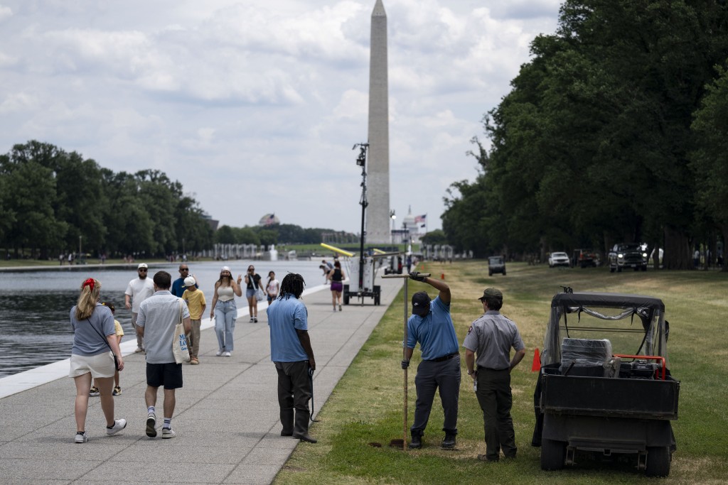 Photo by KENT NISHIMURA / AFP Workers turn a valve at the Lincoln Memorial Reflecting Pool following the completion of recent renovations in Washington, DC, on June 22, 2026.