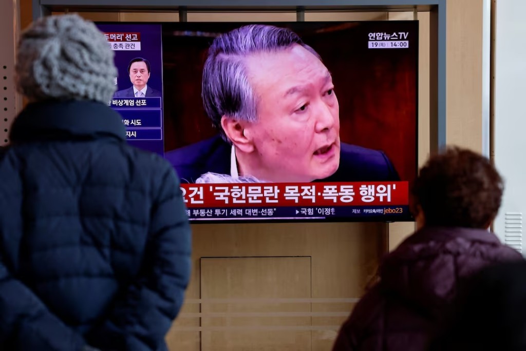  People watch a news report on the sentencing trial of South Korean former president Yoon Suk Yeol's insurrection case, stemming from his short-lived declaration of martial law in December 2024, in Seoul, South Korea, February 19, 2026. REUTERS/Kim Soo-hyeon/File Photo