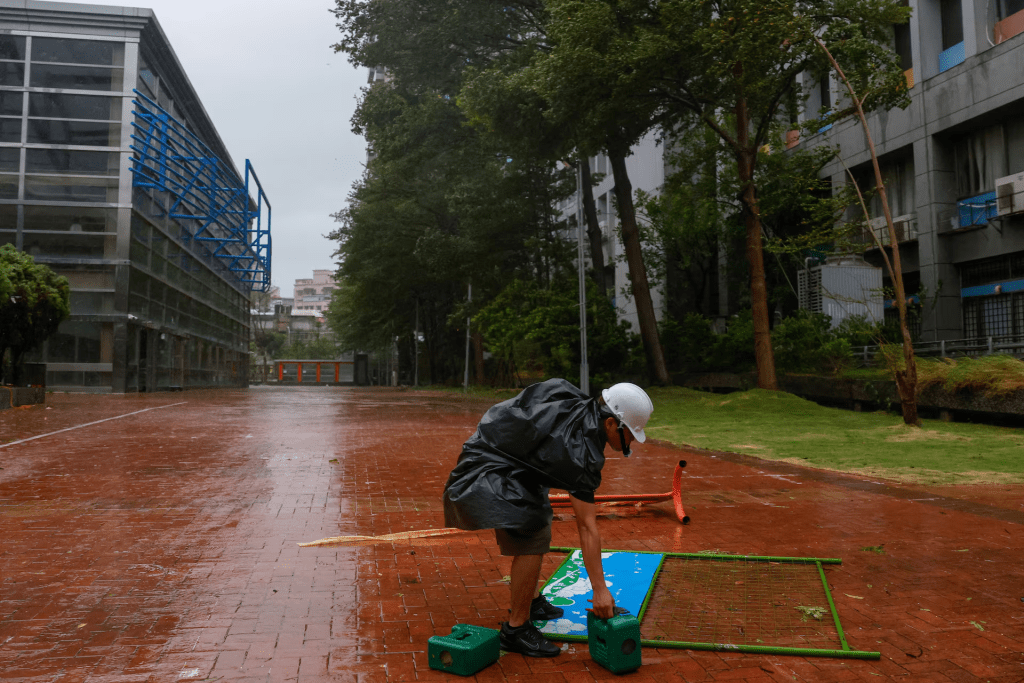 A worker secures a sign as Typhoon Champi approaches Taiwan, in Taipei, Taiwan, October 23, 2026. REUTERS/Ann Wang