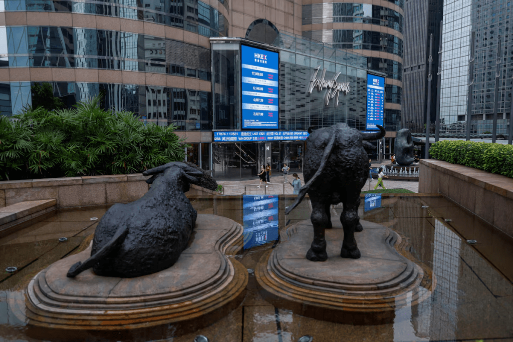 Bull statues are placed in font of screens showing the Hang Seng stock index and stock prices outside Exchange Square, in Hong Kong, China, August 18, 2023. REUTERS/Tyrone Siu/File Photo
