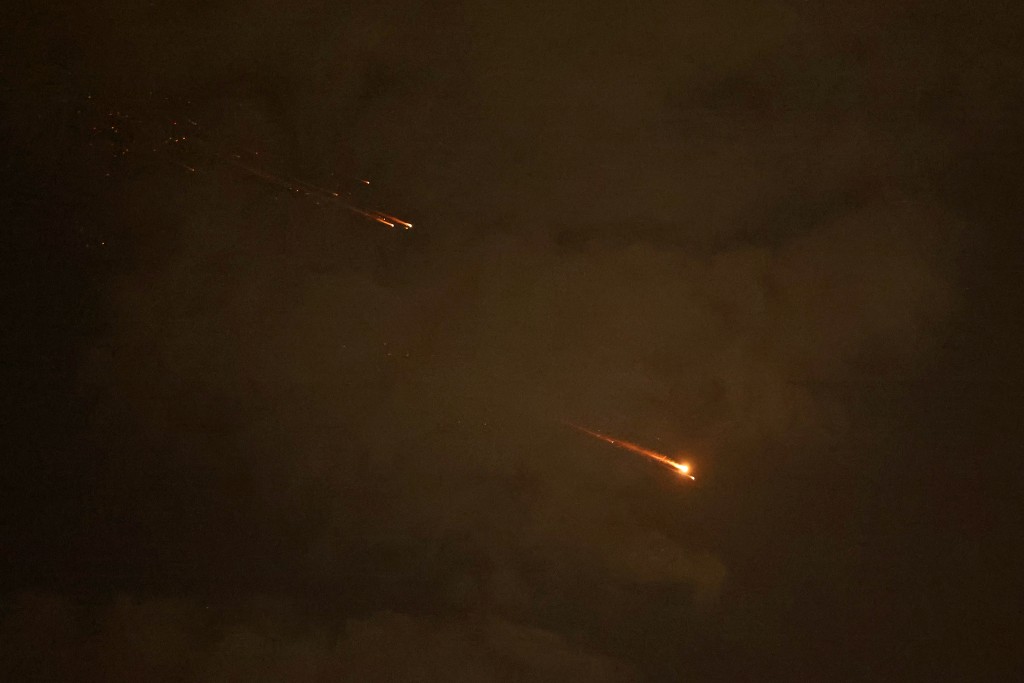 Rocket trails are seen in the sky above the Israeli coastal city of Netanya amid a fresh barrage of Iranian missile attacks on April 6, 2026. (AFP)