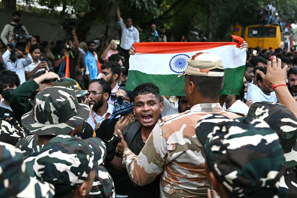A supporter of India's opposition Congress party holds the country's national flag as he scuffles with security personnel during a protest demanding the resignation of the nation's Chief Election Commissioner Gyanesh Kumar over alleged voter roll irregularities linked to the "special intensive revision" (SIR), in New Delhi on October 12, 2026.