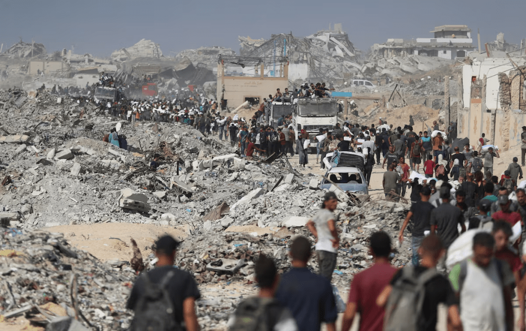 Palestinians carry aid supplies that entered Gaza through Israel, in Beit Lahia, northern Gaza Strip, August 2, 2025. REUTERS/Mahmoud Issa/File Photo 