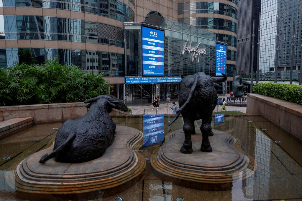 Bull statues are placed in font of screens showing the Hang Seng stock index and stock prices outside Exchange Square, in Hong Kong, China, August 18, 2023. REUTERS/Tyrone Siu/File Photo/File Photo