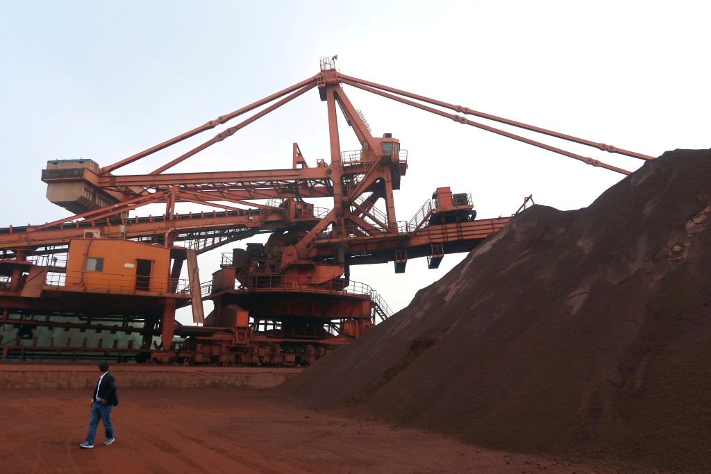 A man walks by the iron ore blending site at Dalian Port, Liaoning province, China, 2018. REUTERS