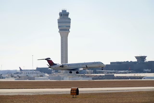 A plane flies near an air traffic control tower at Hartsfield-Jackson Atlanta International Airport in Georgia, U.S. February 1, 2025. REUTERS/Megan Varner/File Photo A plane flies near an air traffic control tower at Hartsfield-Jackson Atlanta International Airport in Georgia, U.S. February 1, 2025. REUTERS/Megan Varner/File Photo