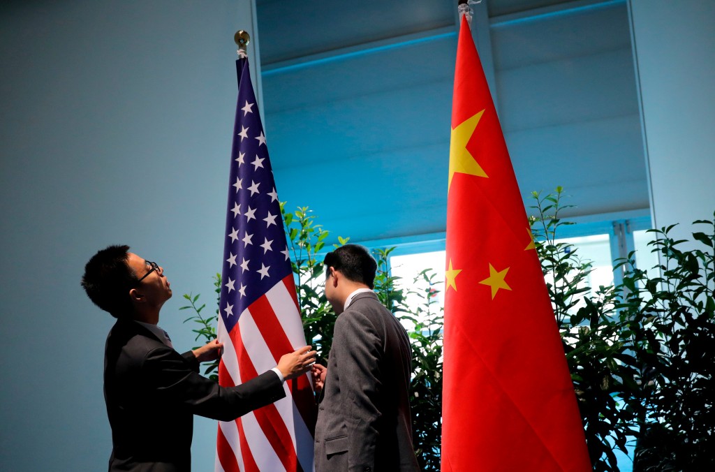 Chinese officials prepare the flags for the China-U.S. bilateral meeting at the G20 leaders summit in Hamburg, Germany July 8, 2017. REUTERS