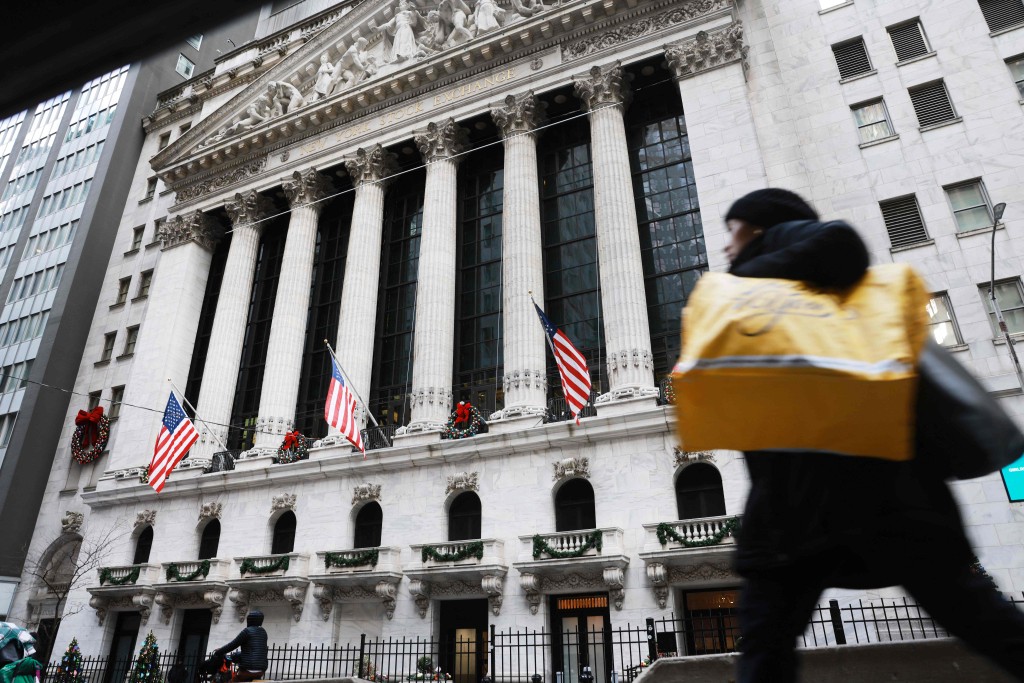 People walk by the New York Stock Exchange (NYSE) on December 30, 2025 in New York City. Spencer Platt/Getty Images/AFP  