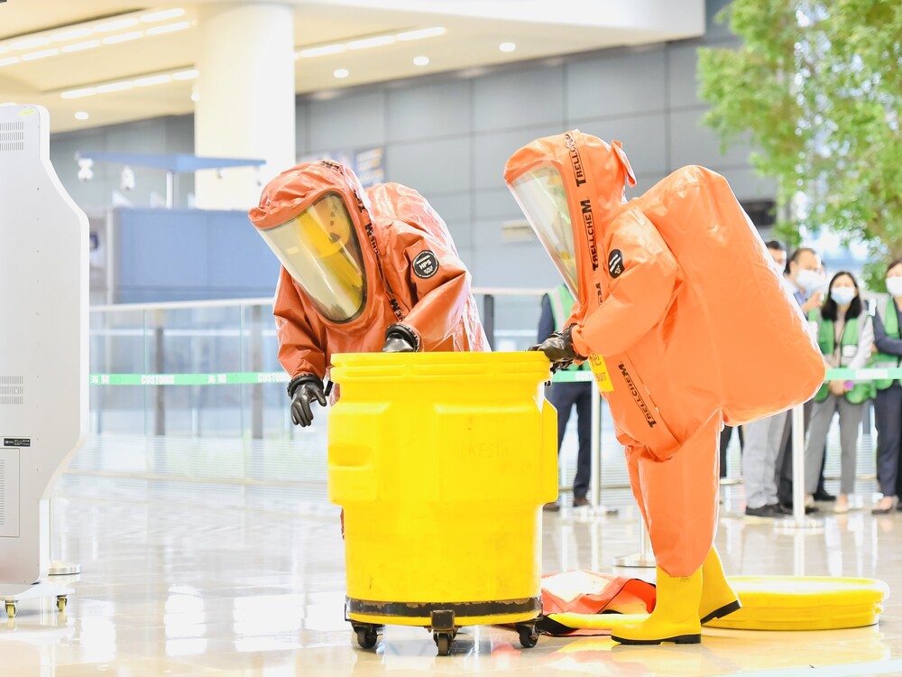 FSD officers wearing chemical protection suits handling hazardous material at the scene during the drill.