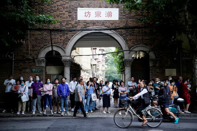Parents wait for students behind a police line during the annual national college entrance exam, or "gaokao", at a high school in Shanghai, China June 7, 2023. REUTERS/Aly Song/File Photo 
