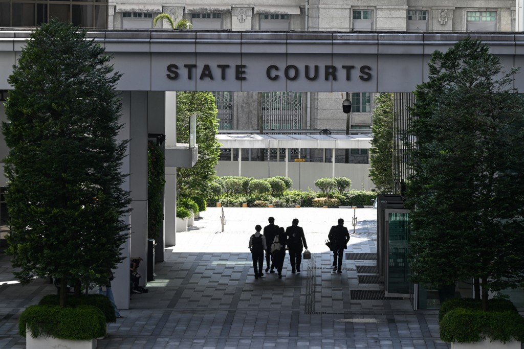 People walk through the State Court building in Singapore on June 26, 2026. (Photo by Roslan RAHMAN / AFP)