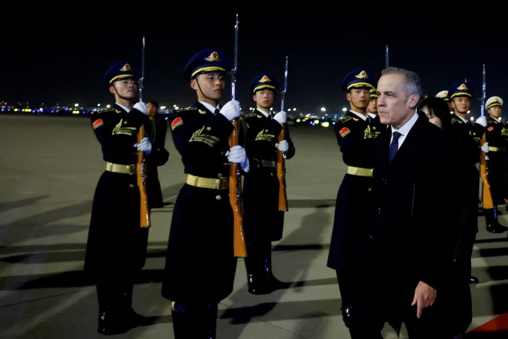 Canada's Prime Minister Mark Carney inspects the honour guard upon his arrival at Beijing Capital International Airport, during the first visit by a Canadian Prime Minister to China since 2017, in Beijing, China January 14, 2026. REUTERS/Carlos Osorio