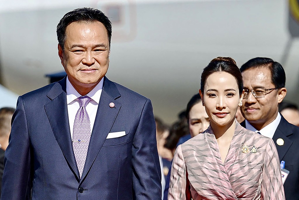 This handout photo taken and released by the Royal Thai Government on October 16, 2025 shows Thailand prime minister Anutin Charnvirakul and his wife Thananon Niramit being welcomed upon arrival for an official state visit at Wattay International Airport in Vientiane. (Photo by Handout / ROYAL THAI GOVERNMENT / AFP)