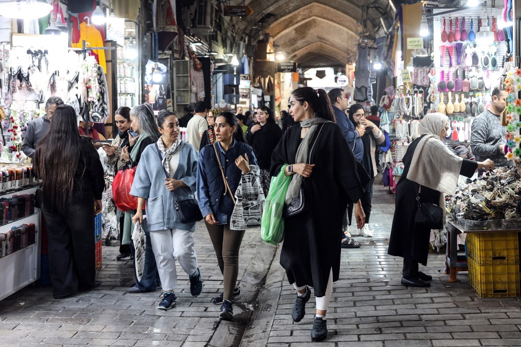 Photo by - / AFP  Iranian women walk through Tehran's Grand Bazaar on February 24, 2026.