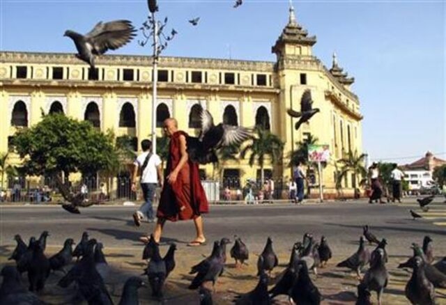 A Buddhist monk walks past the City Hall in downtown Yangon November 5, 2010. REUTERS/stringer