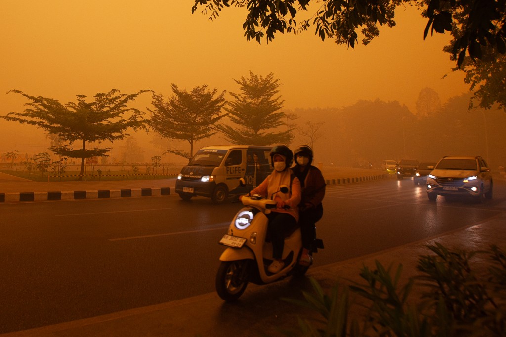 Photo by REINA / AFP  Motorists commute in the morning in Palangkaraya, Central Kalimantan on October 14, 2026, amid thick haze from forest and land fires in the region.