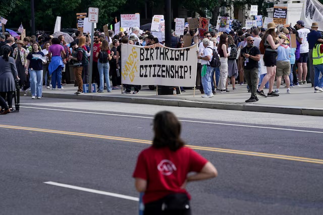 People protest on the day the Supreme Court justices hear oral arguments over U.S. President Donald Trump's bid to broadly enforce his executive order to restrict automatic birthright citizenship, outside the U.S. Supreme Court in Washington, D.C., U.S., May 15, 2025. REUTERS/Nathan Howard/File Photo 