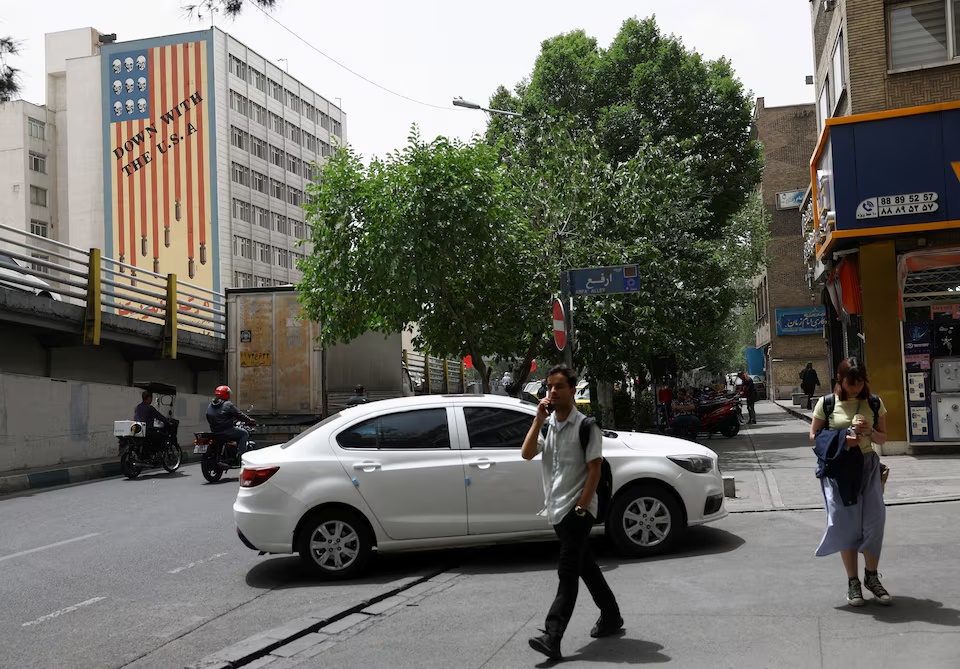 People walk near an anti-U.S. mural on a building in Tehran, Iran, May 19, 2026. Majid Asgaripour/WANA (West Asia News Agency) via REUTERS
