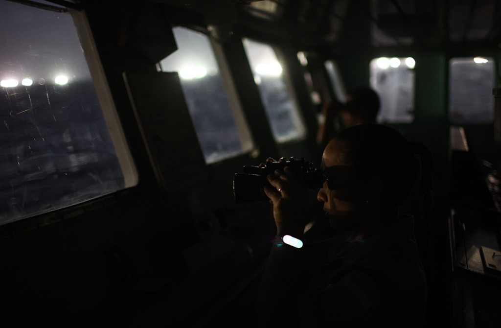 Ludmila Lugo, member of the Argentine coast guard, looks through binoculars at squid jigger vessels aboard the patrol ship Azopardo (GC-25), outside Argentina's exclusive economic zone in the South Atlantic Ocean on January 18, 2026. REUTERS/Agustin Marcarian.