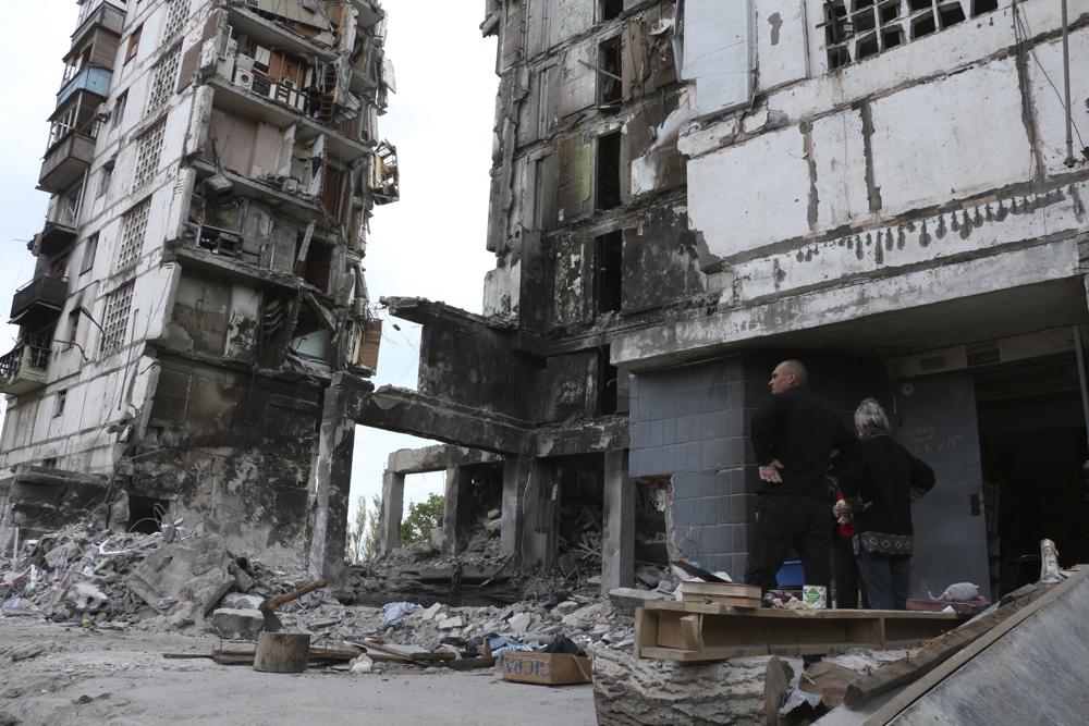 Local residents stand at the side of damaged during a heavy fighting buildings in Mariupol. (AP) Local residents stand at the side of damaged during a heavy fighting buildings in Mariupol. (AP)
