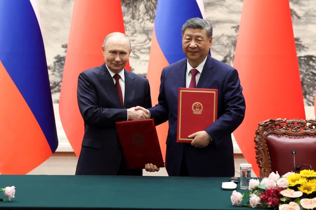 Russian President Vladimir Putin and Chinese President Xi Jinping shake hands during a signing ceremony at the Great Hall of the People in Beijing, China May 20, 2026. REUTERS/Maxim Shemetov/Pool