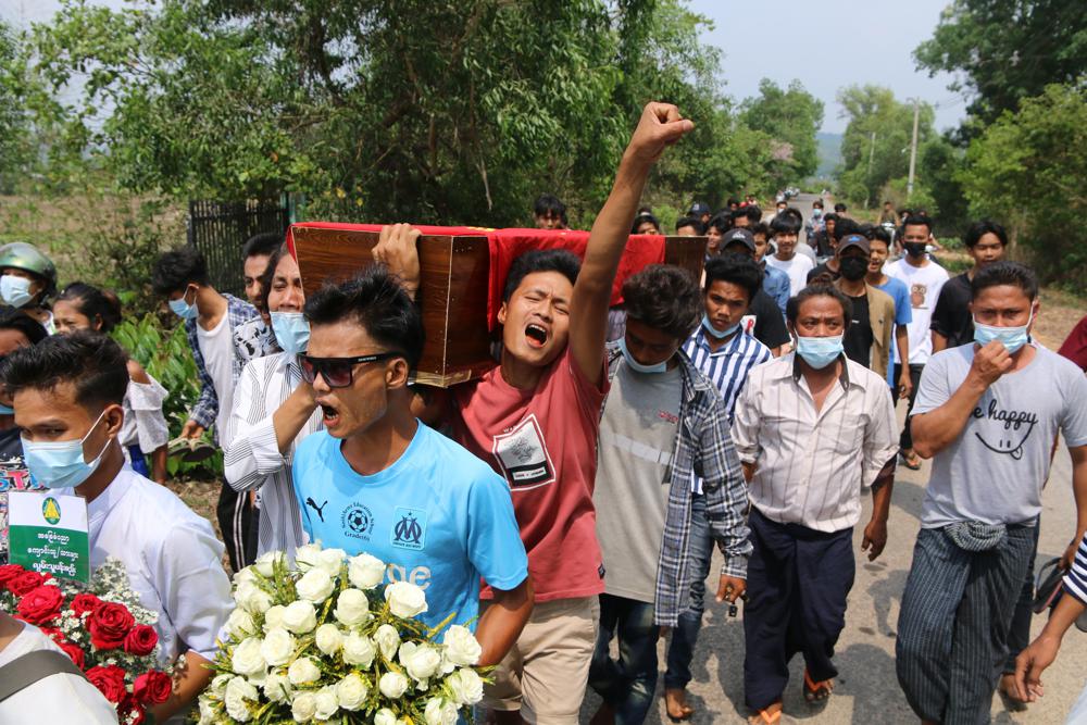 In this April 1, 2021 photo provided by Dawei Watch news outlet, a man raises his hand with a clenched fist as he carries the coffin of 17-year old Kyaw Min Latt during a funeral procession in Dawei, Myanmar. Since the military seized control of Myanmar in a takeover on Feb. 1, more than 825 people have been killed _ well over two times the official tally _ according to watchdog group Assistance Association for Political Prisoners.