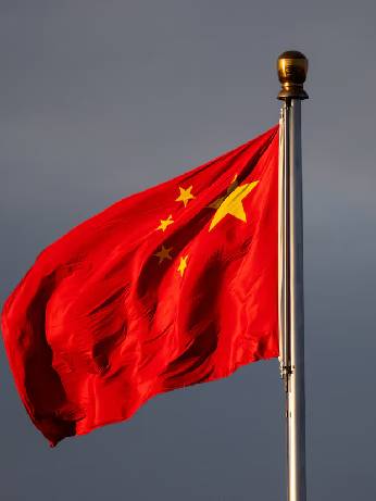 China’s national flag flutters in the wind lit by sunrise in Beijing, China, November 20, 2025. REUTERS/Maxim Shemetov 