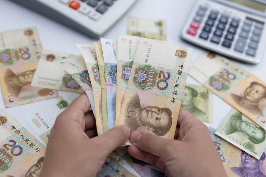 Woman holds Chinese Yuan banknotes in this illustration taken May 30, 2022. REUTERS