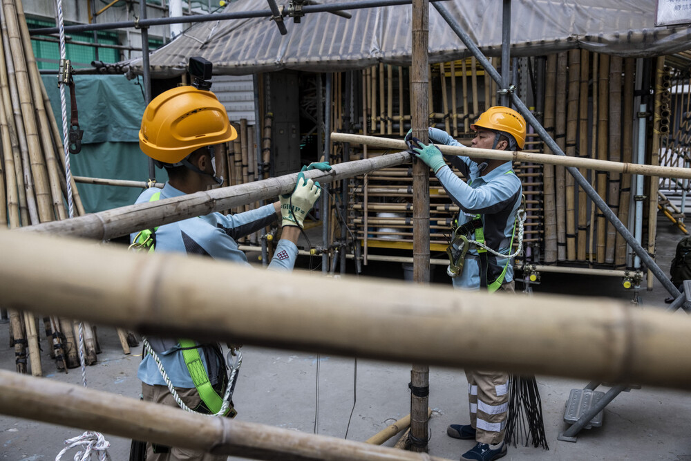 This picture taken in Hong Kong on March 2, 2023 shows students Ho Cheuk-wai (R) and Mo Jia-Yu (L) tying bamboo polls together at the Hong Kong Institute of Construction during a bamboo scaffolding class. The world's most skyscraper-laden metropolis is also one of the last remaining major cities to use bamboo scaffolding for modern construction and building repair. (AFP/Isaac Lawrence) This picture taken in Hong Kong on March 2, 2023 shows students Ho Cheuk-wai (R) and Mo Jia-Yu (L) tying bamboo polls together at the Hong Kong Institute of Construction during a bamboo scaffolding class. The world's most skyscraper-laden metropolis is also one of the last remaining major cities to use bamboo scaffolding for modern construction and building repair. (AFP/Isaac Lawrence)
